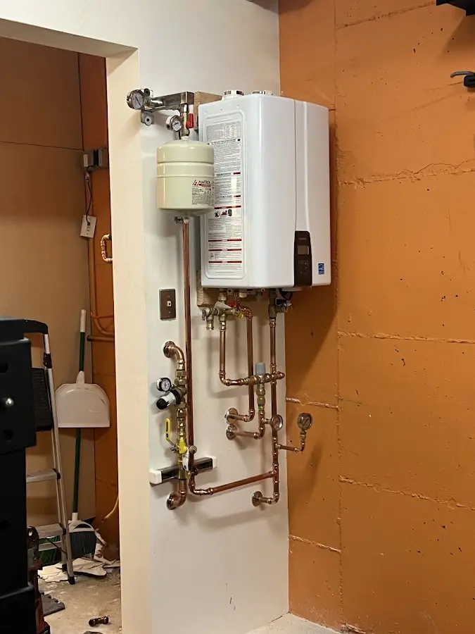 Plumbing technician inspecting water heater connections in Brackenridge